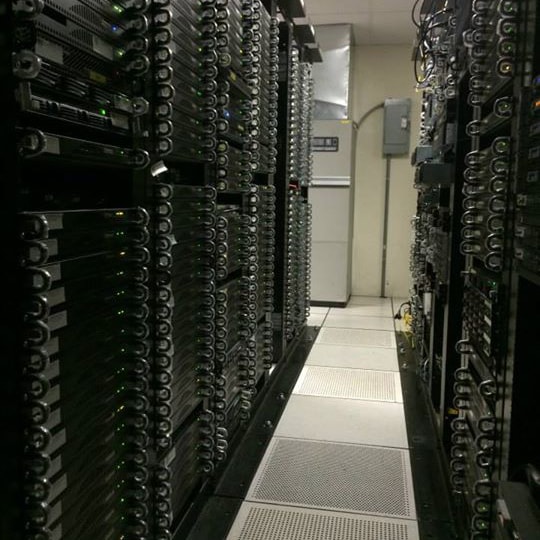 Pasillo entre racks de servidores con piso técnico